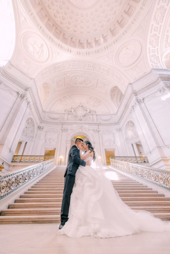 Anh and Tuan embracing at the base of the grand staircase