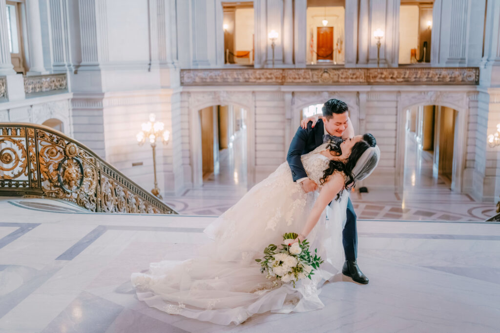 Casey and Minh embracing at the top of the stairs