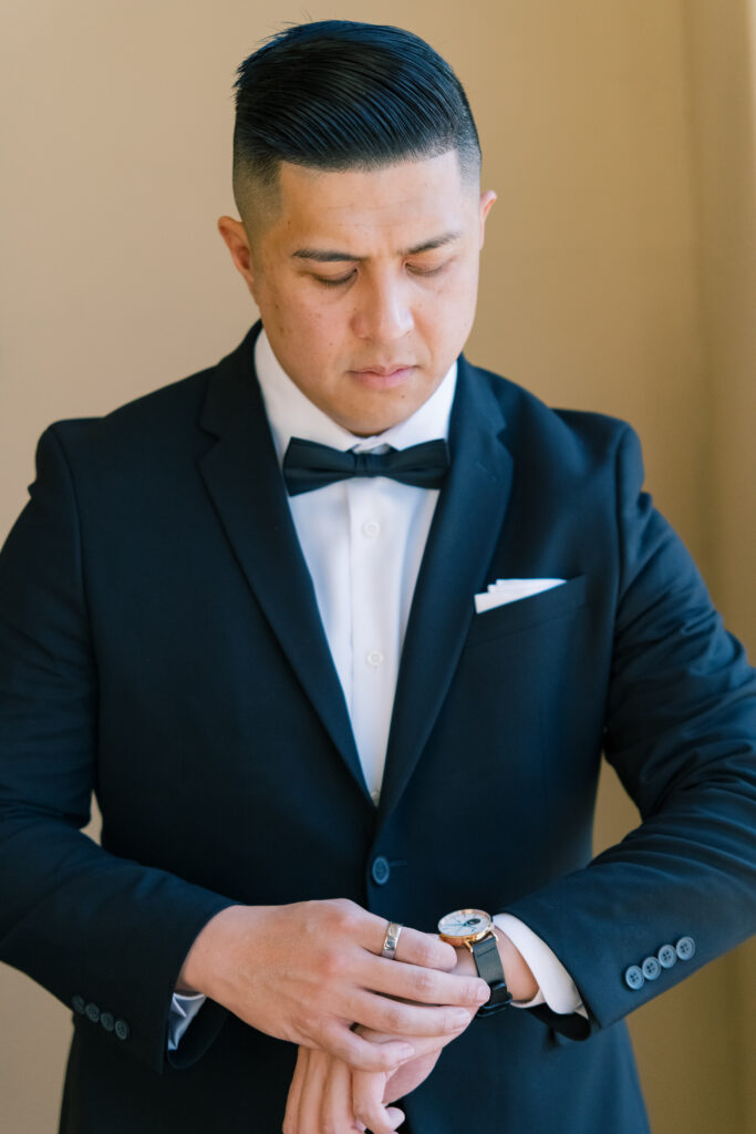 Cesar taking a moment to adjust his watch before the ceremony