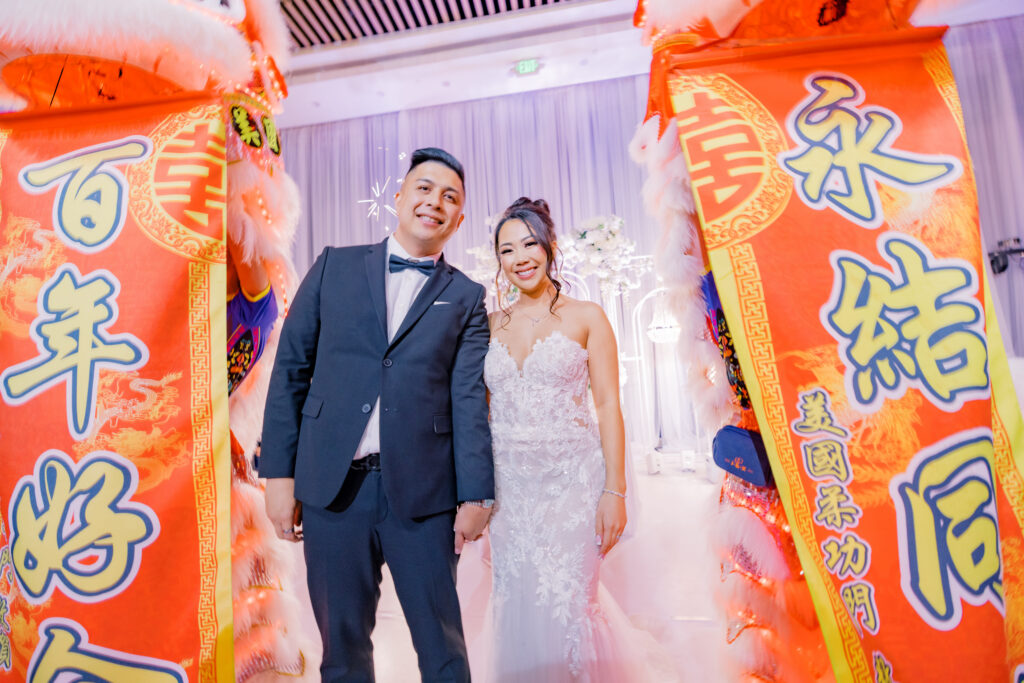 Jocelyne and Cesar smiling together framed by the lion dancers