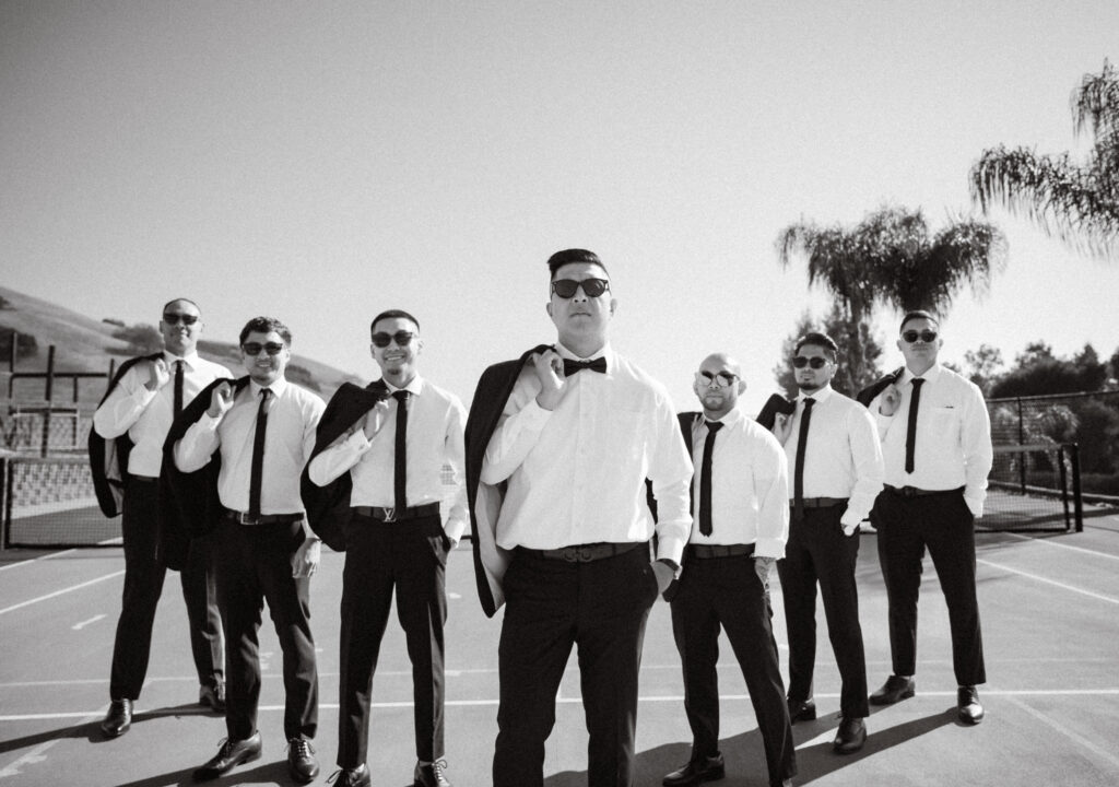 Cesar and his groomsmen pulling their jackets over their shoulders before the day begins