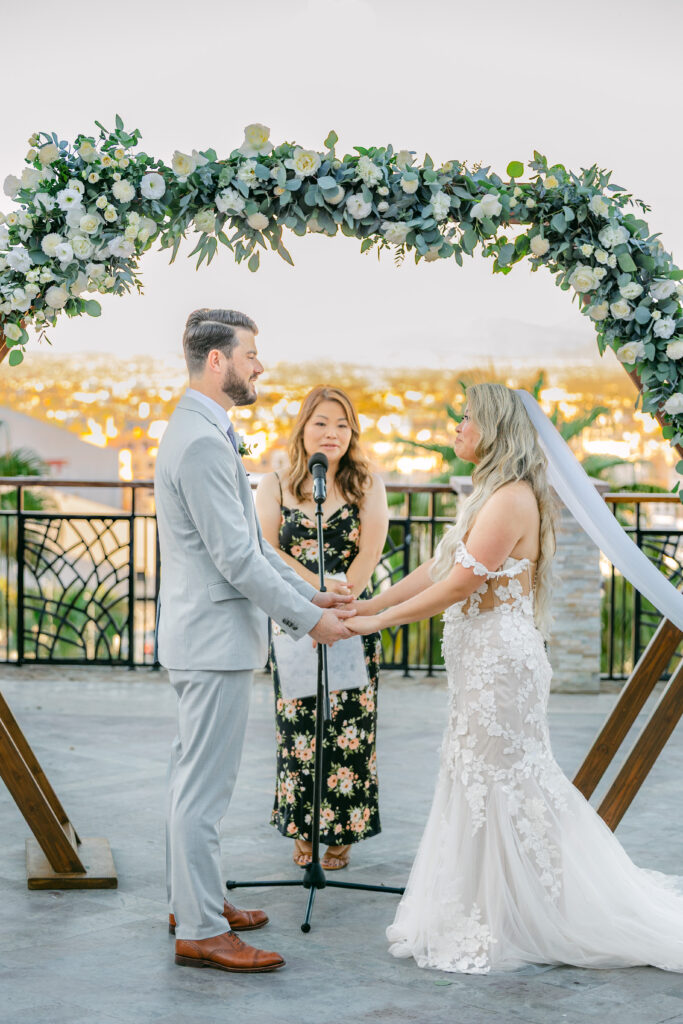 Jennifer and Chris exchanging vows under a floral arch