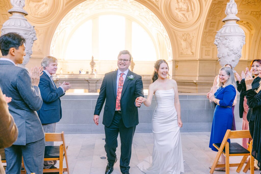 Matt and Clare walk down the aisle as newlyweds, beaming