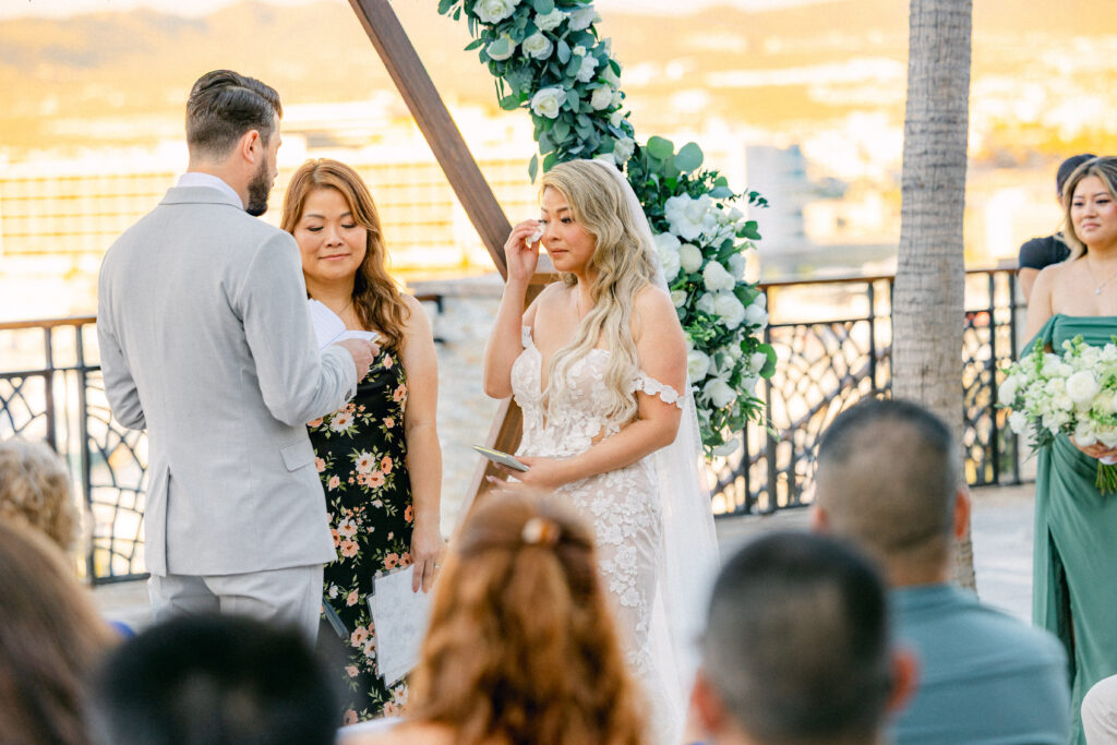Jennifer wiping tears from her eyes during an outdoor ceremony