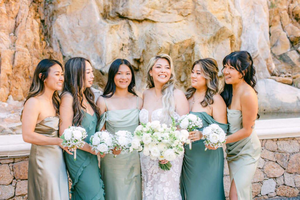 Jennifer and her bridesmaids in green dresses holding white bouquets