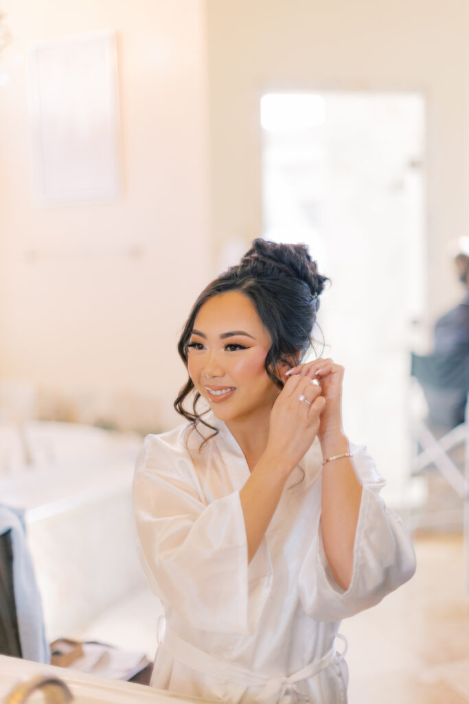 Jocelyne putting on her earrings in the morning before the ceremony