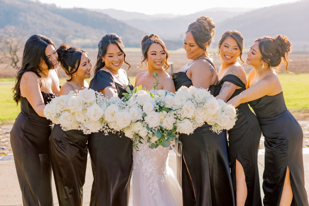 Jocelyne and her bridesmaids gathering together outside with their bouquets
