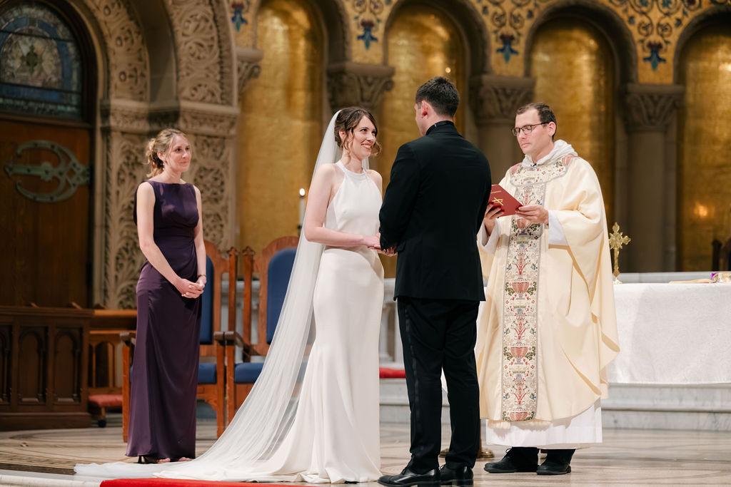 Makenna and Nicholaus exchanging vows at the altar