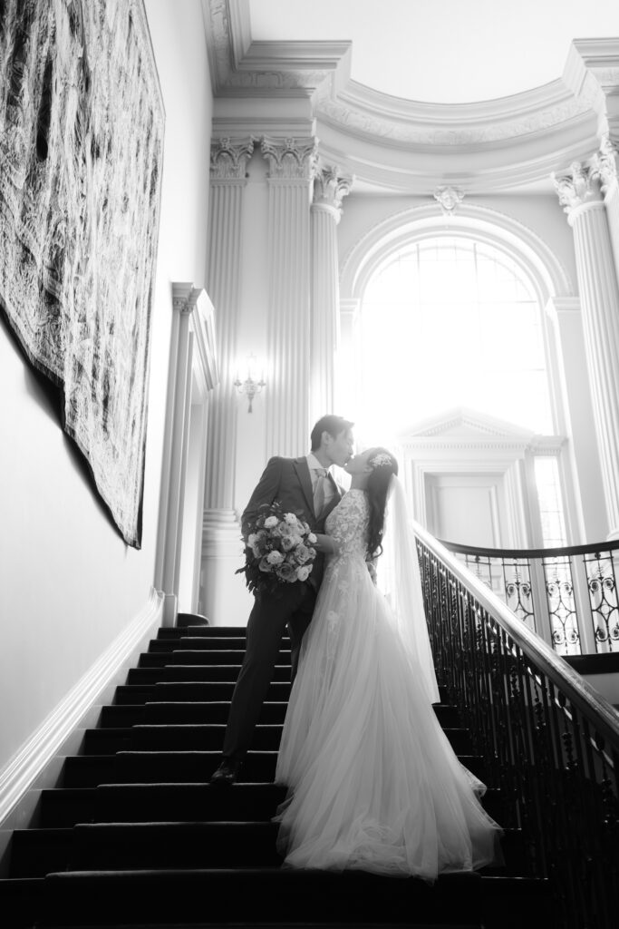 Monica and Kevin kissing on the Filoli mansion staircase