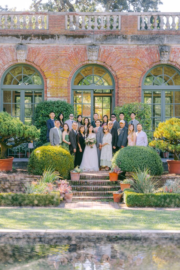 Portrait of Monica and Kevin with the wedding party in front of Filoli conservatory