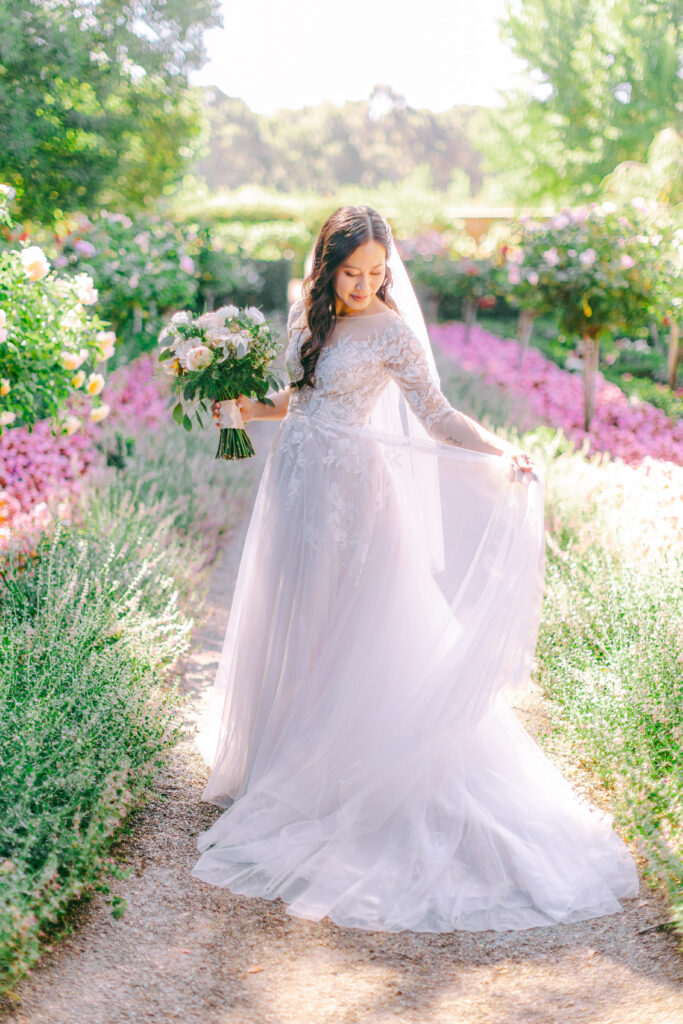 Monica walking through Filoli rose garden in lace gown