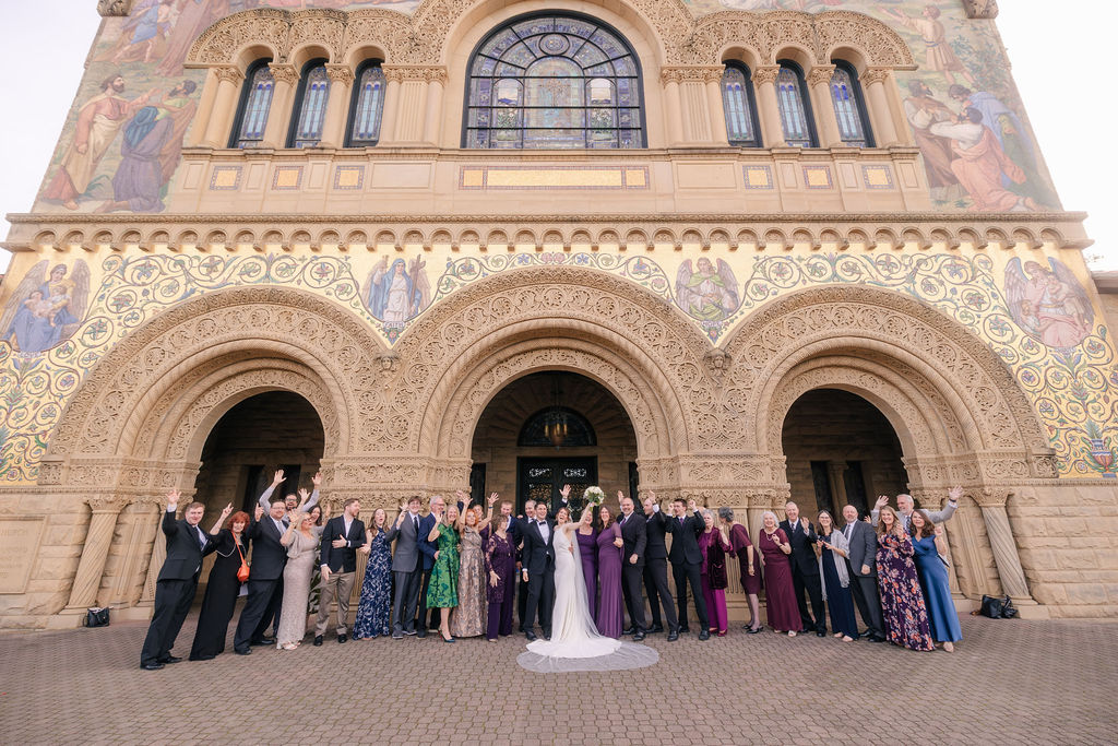 Makenna and Nicholaus with their wedding guests cheering in front of Stanford Memorial Church