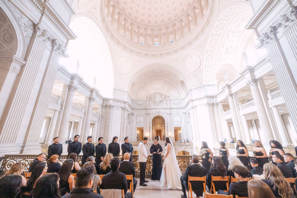 Couple holding hands during their San Francisco City Hall wedding ceremony on the second-floor Mayor's Balcony